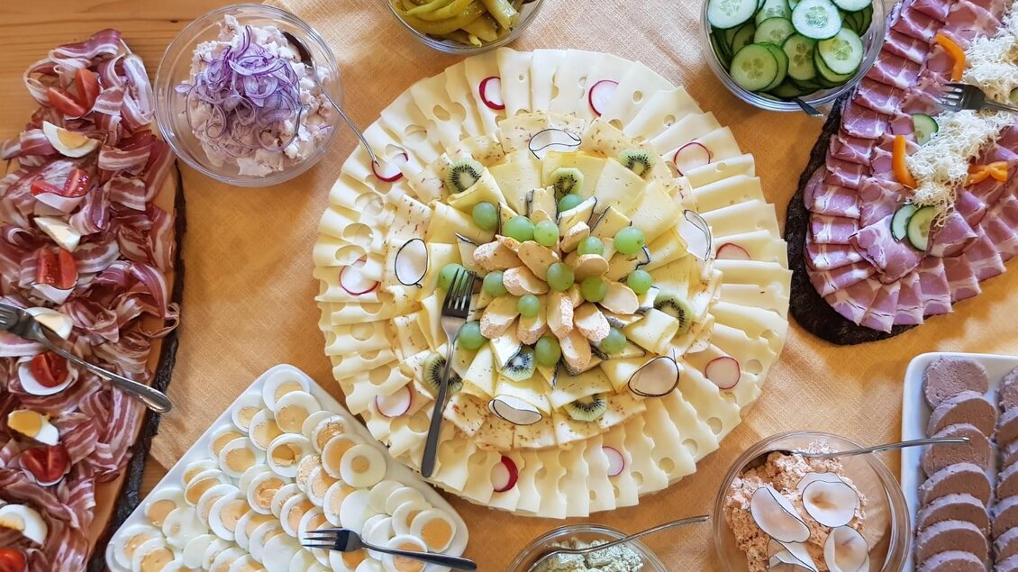 Ein Buffet mit verschiedenen kalten Speisen, darunter Käse- und Wurstplatten, Gemüse und Eier. Die Anordnung der Speisen ist ansprechend und einladend. | © Andreas Wutti | Weingut Buschenschank Wutti