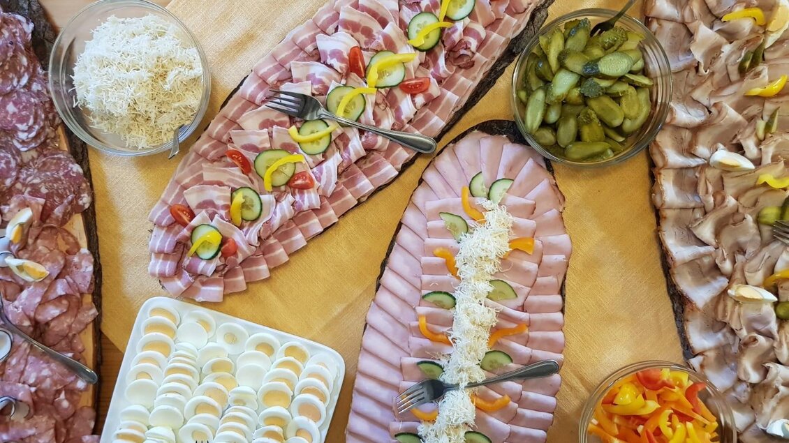 Ein reichhaltiges Buffet mit verschiedenen Wurst- und Käseplatten. Dazu gibt es eingelegtes Gemüse und bunte Paprikastücke in Schalen. | © Andreas Wutti | Weingut Buschenschank Wutti