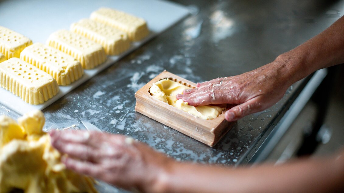 Hände formen frische Seife in einer Form. Im Hintergrund sind weitere Seifenstücke sichtbar. | © TV Murau