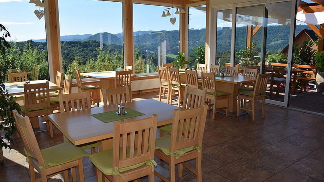 Ein gemütliches Restaurant mit Holzstühlen und Tischen. Man hat einen schönen Blick auf die Berge. | © Walter Christian Zitz | Weinhof Zitz