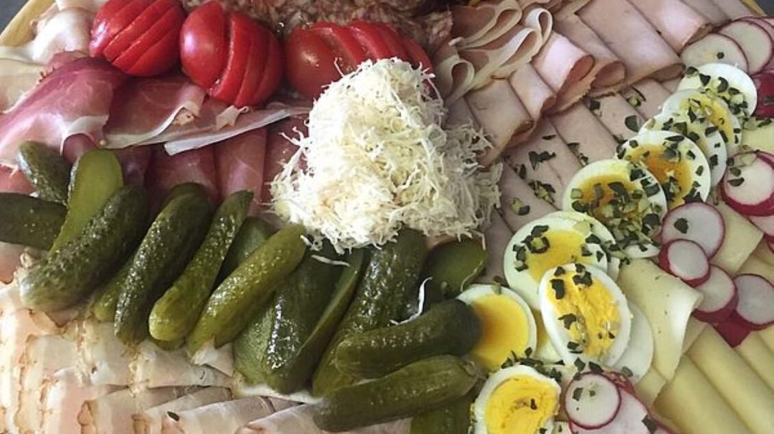 Ein großer Teller mit verschiedenen Wurstsorten, Käse, Eiern und Gemüse. Frische Tomaten, Essiggurken und Radieschen ergänzen die Auswahl. | © Walter Christian Zitz | Weinhof Zitz