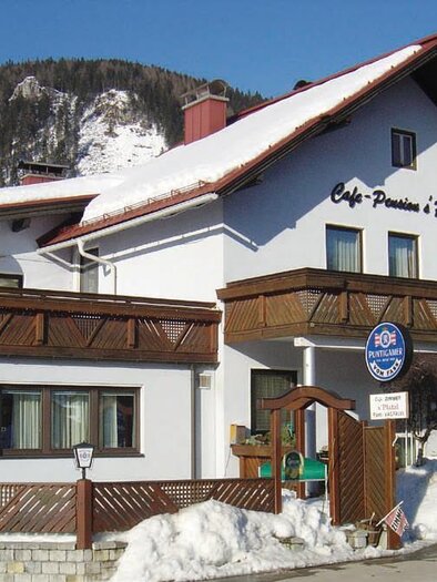 A charming café in a snow-covered landscape. The building has a balcony and an inviting atmosphere. | © Polleros