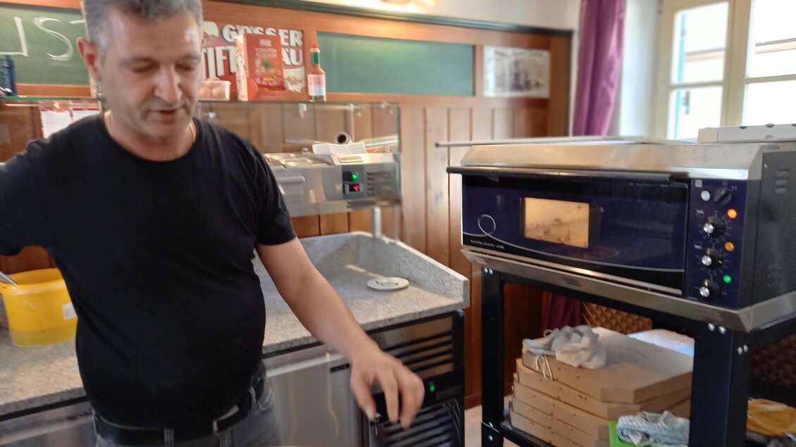 Ein Mann in einem Restaurant bereitet frisches Brot vor. Im Hintergrund sieht man einen modernen Ofen und verschiedene Kochutensilien. | © Thermen- & Vulkanland