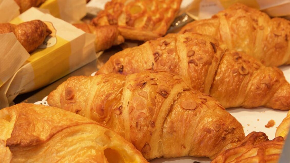 Leckere, goldene Croissants und Gebäck liegen auf einem Tisch. Die Backwaren sind frisch und knusprig. | © Rainer M. Fürstaller