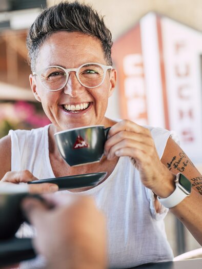 <p>Eine Frau ist im Cafe Fuchs zu sehen mit einer Tasse Cafe in der Hand.</p> | © Bernhard Bergmann