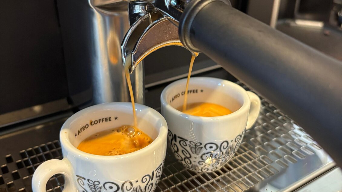 Zwei Tassen Kaffee werden frisch zubereitet. Der Kaffee fließt gleichmäßig aus der Kaffeemaschine. | © Café Hirzenberger