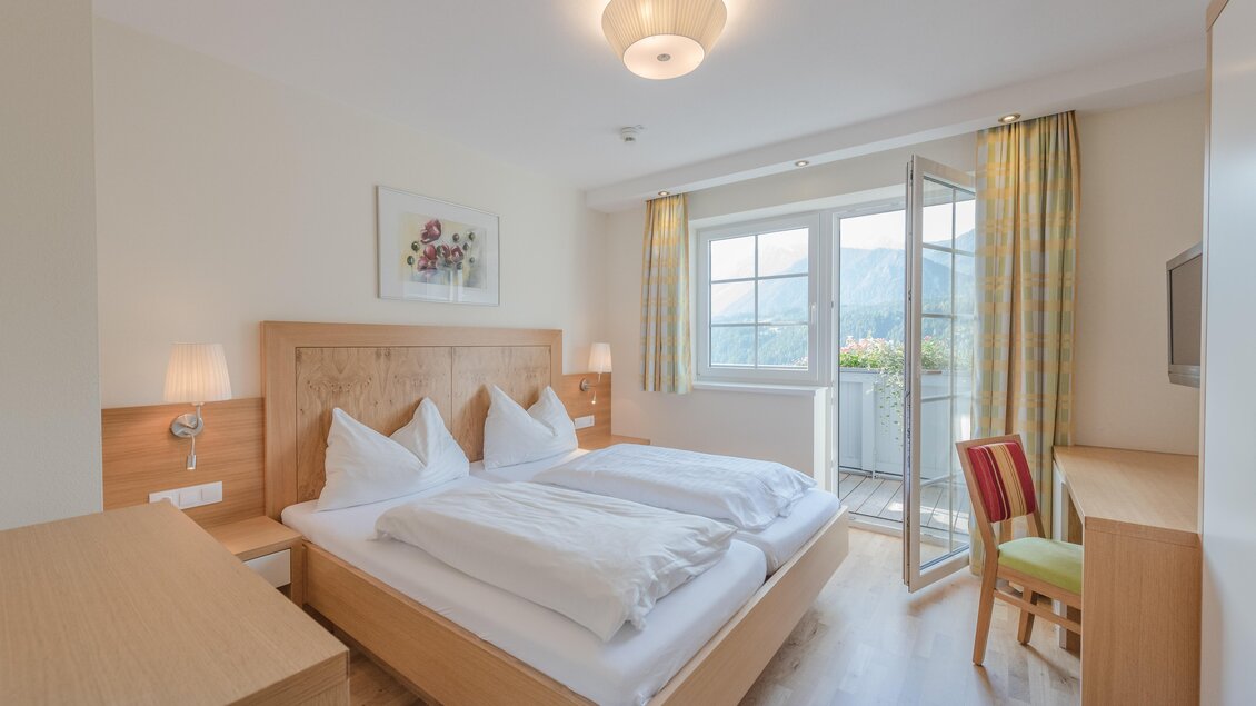 Ein helles und modernes Schlafzimmer mit zwei Einzelbetten. Großer Fensterblick auf den Balkon und freundliche Farben. | © Christine Höflehner