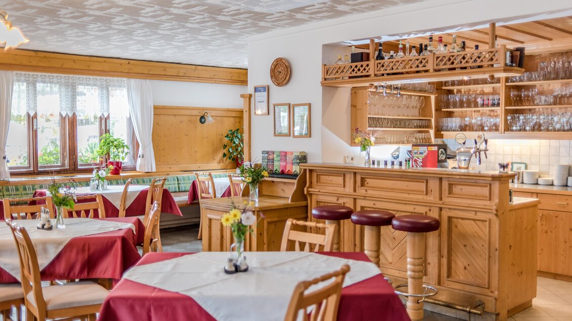 Ein gemütliches Restaurant mit Holzinterieur und rot-weißen Tischdecken. Die Bar ist gut bestückt und es gibt viel Tageslicht durch die Fenster. | © Christine Höflehner