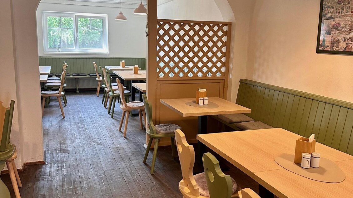 Ein gemütliches Restaurant mit hölzernen Tischen und bunten Stühlen. Die Einrichtung ist hell und einladend, mit einer freundlichen Atmosphäre. | © Café Sophia