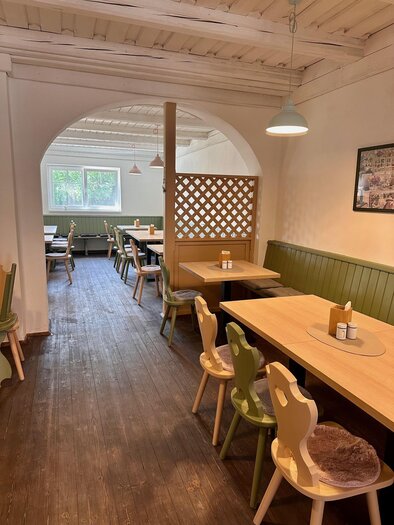 Ein gemütliches Restaurant mit hölzernen Tischen und bunten Stühlen. Die Einrichtung ist hell und einladend, mit einer freundlichen Atmosphäre. | © Café Sophia