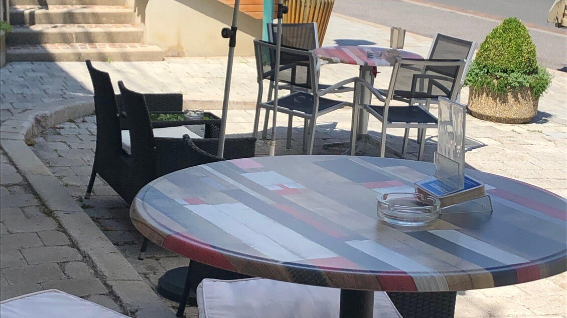 Ein kleines Café im Freien mit einem runden Tisch und Stühlen. Die Atmosphäre ist entspannt und einladend. | © Josy Lammers