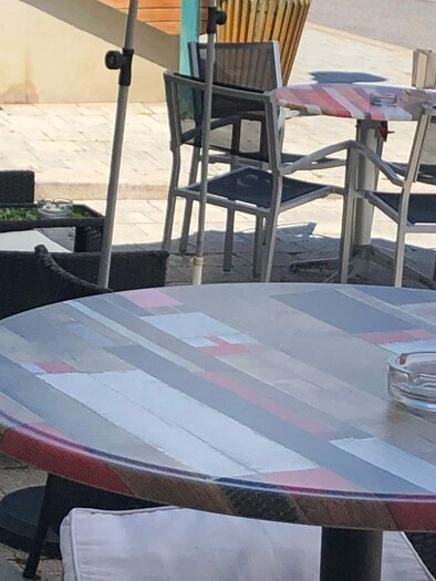 Ein kleines Café im Freien mit einem runden Tisch und Stühlen. Die Atmosphäre ist entspannt und einladend. | © Josy Lammers