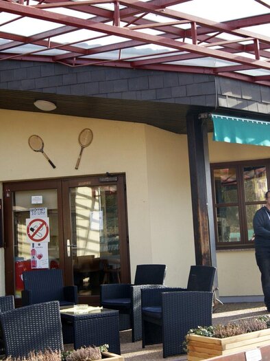 Ein Tennisclub mit einem modernen Gebäude und einem Außenbereich. Einige Personen stehen vor dem Eingang und unterhalten sich. | © Gemeinde Gratkorn - Gasser