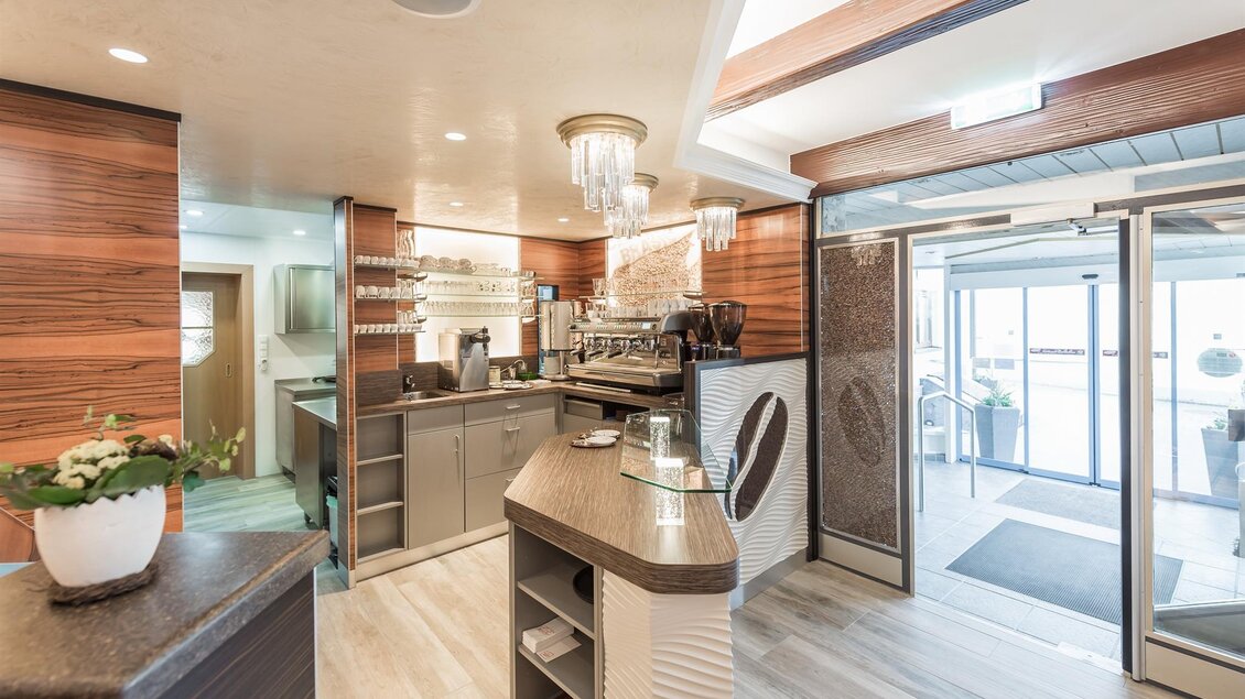 Ein modernes Café mit eleganter Einrichtung und Holzverkleidung. Der Barbereich ist gut beleuchtet und einladend. | © Konditorei Regner