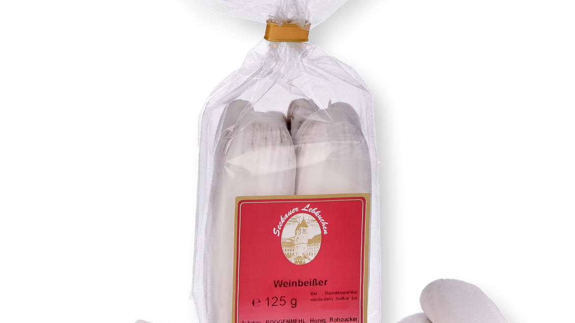 Eine Verpackung mit Weinbeißern, einer süßen Leckerei. Neben der Verpackung liegen einige Weinbeißer auf dem Tisch. | © Konditorei Regner