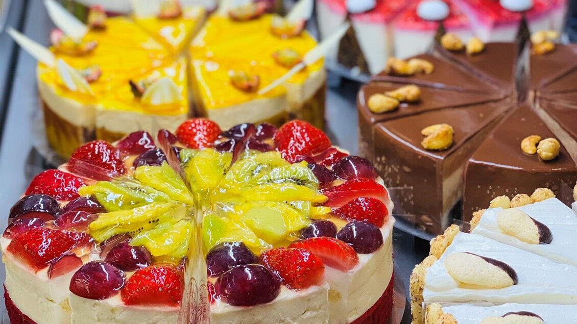Eine Auswahl bunter Torten mit Früchten und Schokolade. Die Desserts präsentieren sich appetitlich in einer Vitrine. | © Konditorei Regner