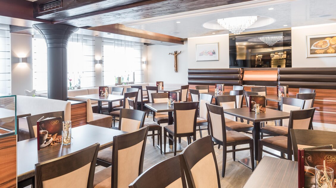 Ein gemütliches Restaurant mit modernen Holzmöbeln und eleganter Beleuchtung. Die Tische und Stühle sind ordentlich angeordnet, und große Fenster sorgen für viel Tageslicht. | © Konditorei Regner