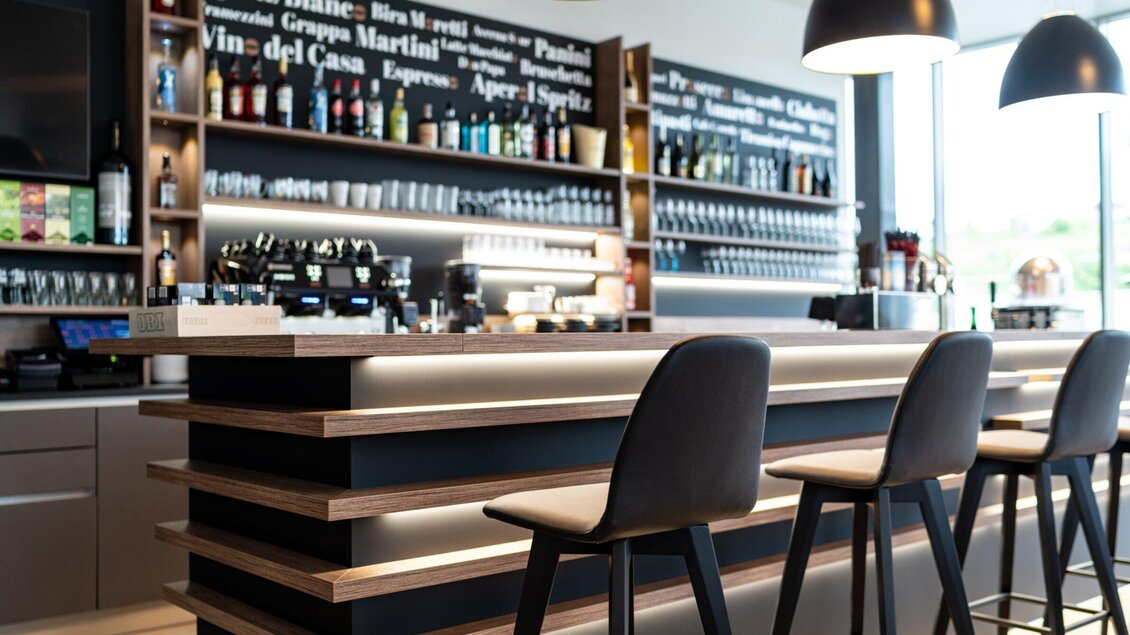 Eine elegante Bar mit einer gut sortierten Getränkeauswahl und stilvollen Sitzplätzen. Der moderne Raum strahlt eine einladende Atmosphäre aus. | © Kalthuber photography
