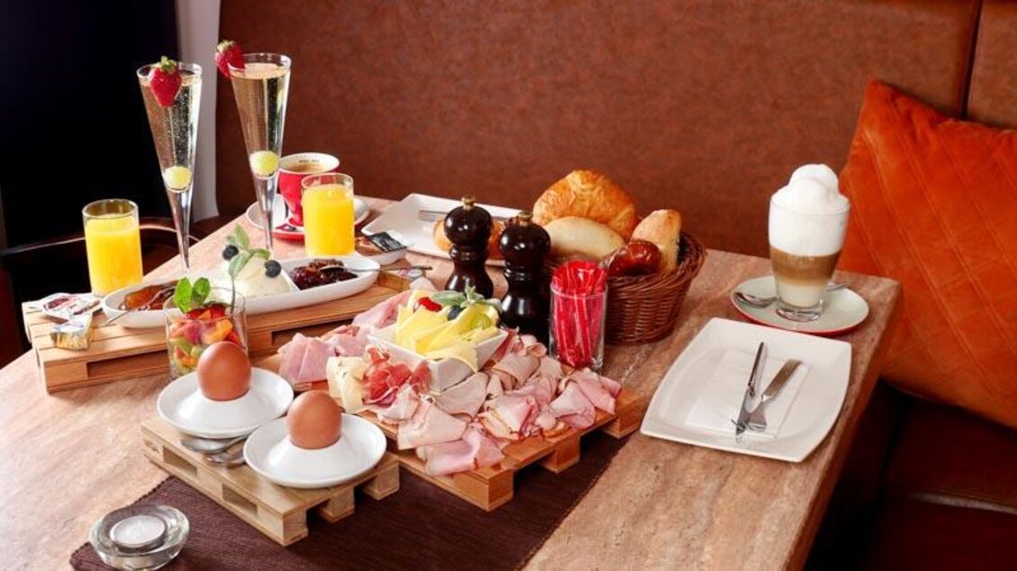 Ein schön gedeckter Tisch mit verschiedenen Frühstücksoptionen. Es gibt frische Brötchen, Aufschnitt, Eier und Getränke. | © Barletti