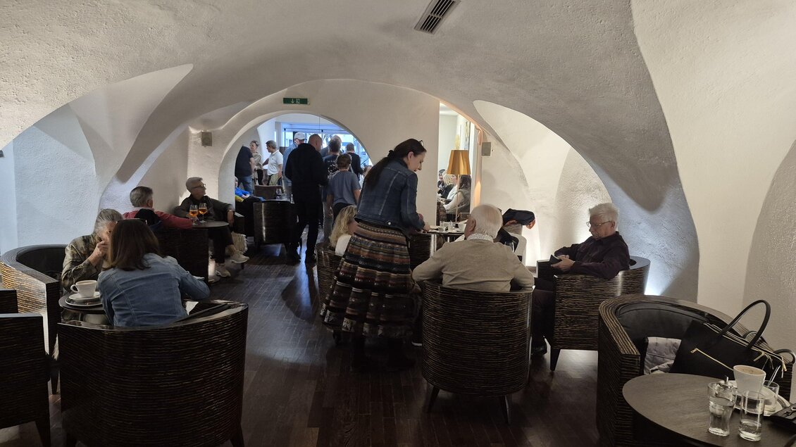 Eine gemütliche Lounge mit mehreren Tischen und Stühlen. Gäste unterhalten sich in einer stilvollen, modernen Atmosphäre. | © TV Hochsteiermark