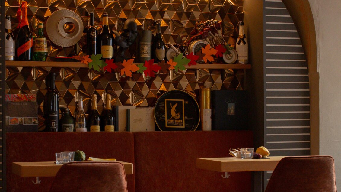 Ein stilvolles Restaurant mit einem gemütlichen Ambiente. Die Bar ist gut gefüllt mit verschiedenen Getränken und dekorativen Elementen. | © Amaro