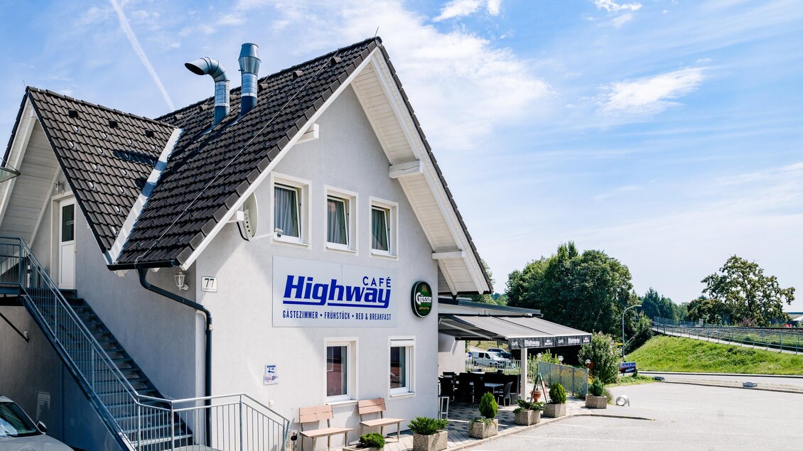 Ein modernes Gebäude mit der Aufschrift "Highway" und einer angrenzenden Treppe. Die Umgebung ist grün und der Himmel ist blau mit einigen Wolken. | © Mias Photoart