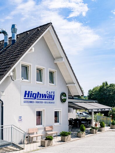 Ein modernes Gebäude mit der Aufschrift "Highway" und einer angrenzenden Treppe. Die Umgebung ist grün und der Himmel ist blau mit einigen Wolken. | © Mias Photoart