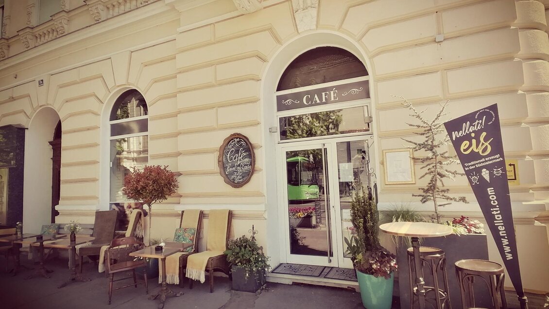 Ein gemütliches Café mit einem einladenden Außensitzbereich. Es gibt Pflanzen und eine Werbung für Eis neben dem Eingang. | © Julia Schoster