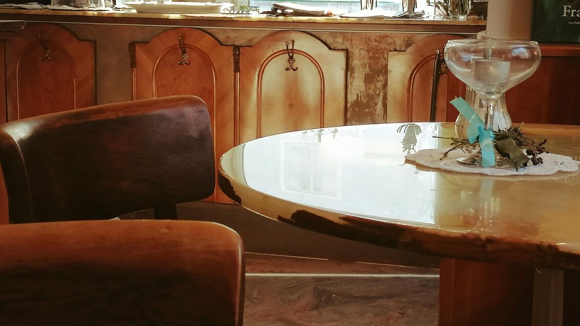 Ein gemütlicher Tisch mit einer dekorativen Schale und einem Stuhl in einem warmen, einladenden Raum. Im Hintergrund sind interessante Dekorationsstücke sichtbar. | © Anton Brandner