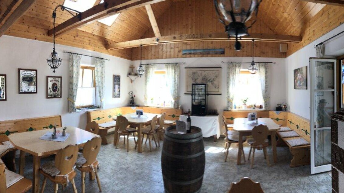 Ein gemütliches Restaurant mit Holzdekor und hübschen Fenstern. Die Tische sind ordentlich gedeckt und es gibt eine rustikale Atmosphäre.