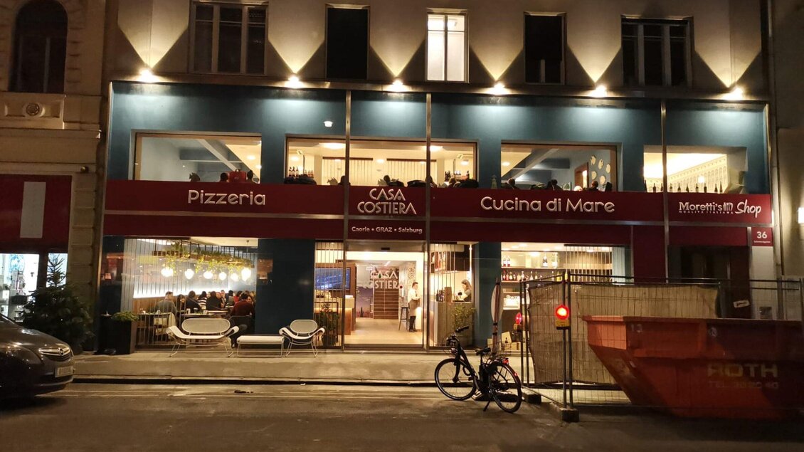 Ein Restaurant mit dem Namen "Casa Costiera" ist bei Nacht beleuchtet. Es bietet italienische Küche an und hat eine einladende Atmosphäre. | © Casa Costiera