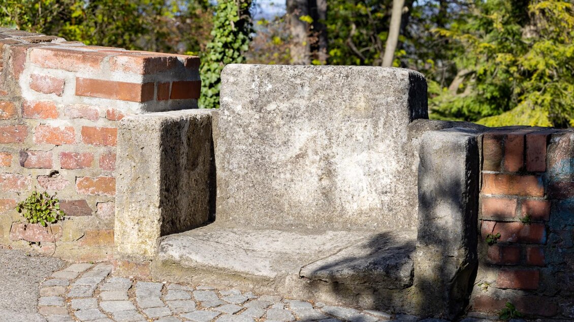 Historischer Steinsitz in der Schlossbergmauer von Graz, umgeben von Backstein | © Graz Tourismus - Harry Schiffer
