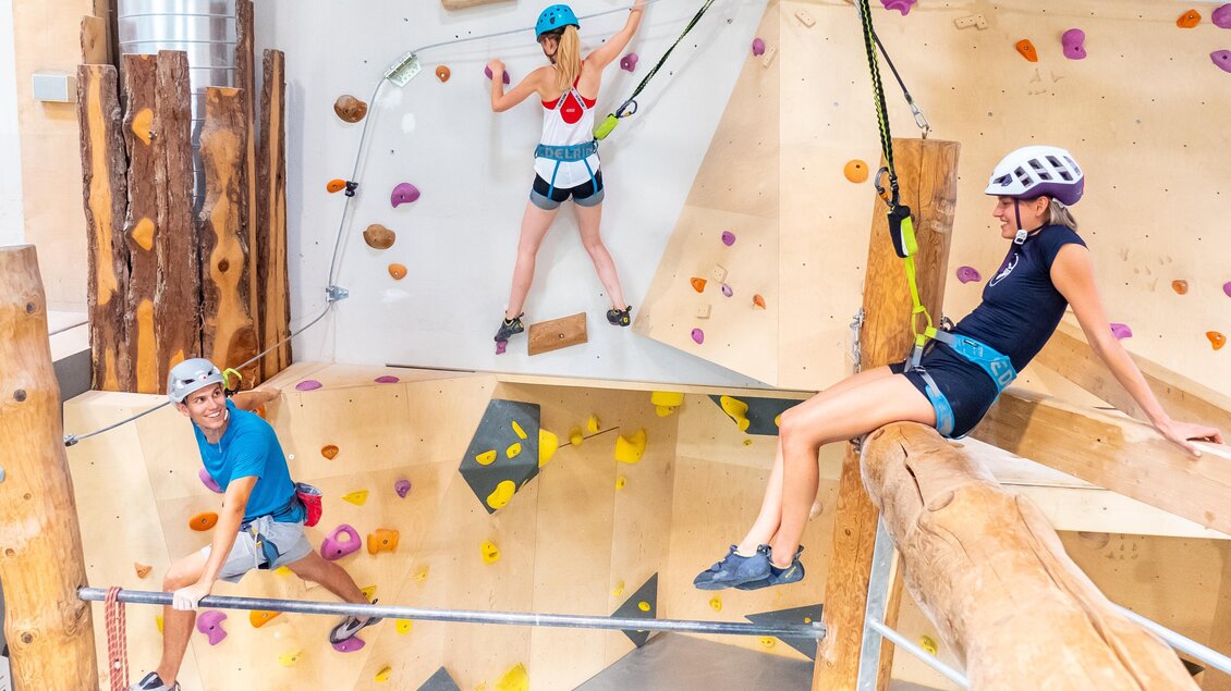 Drei Personen klettern gesichert an bunten Kletterwänden im City Adventure Center Graz | © C-A-C
