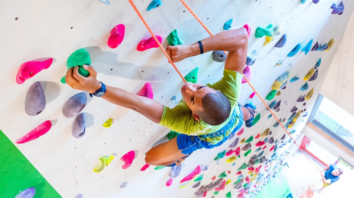 Mann klettert gesichert an steiler Indoor-Kletterwand im City Adventure Center Graz | © C-A-C