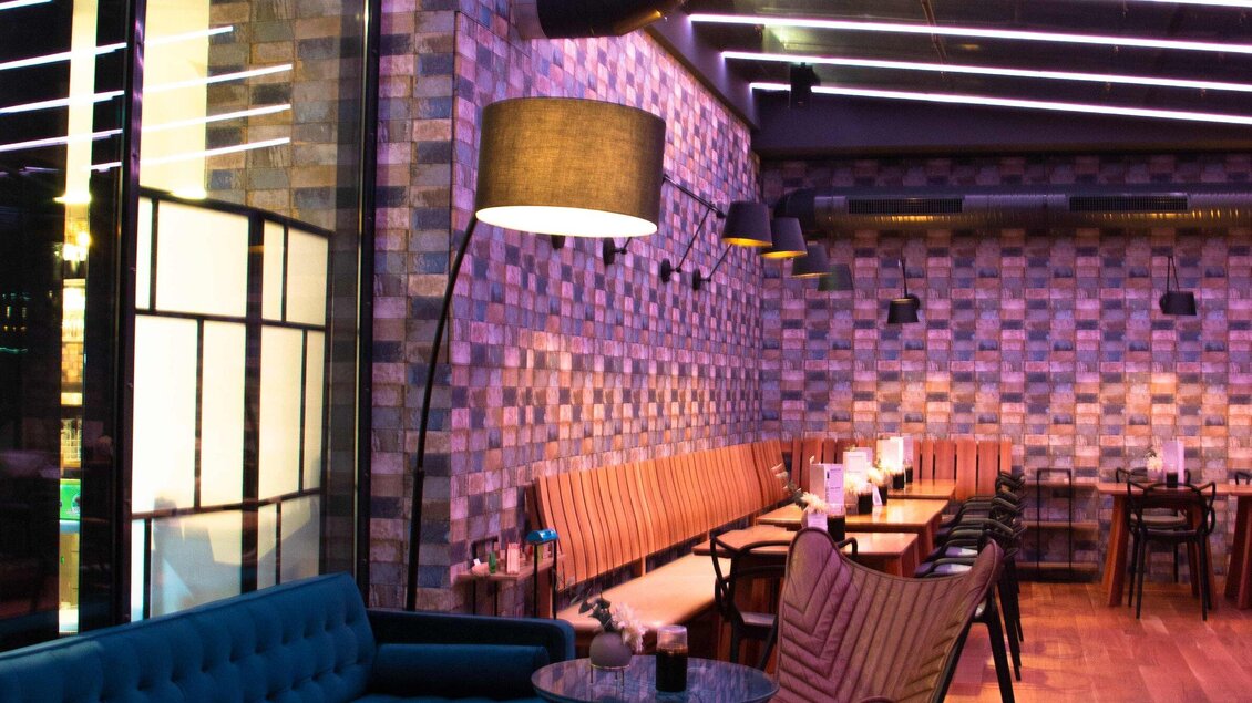 Ein modernes Restaurant mit stilvollem Interieur und bunten Wänden. Gemütliche Sitzgelegenheiten und stimmungsvolle Beleuchtung schaffen eine einladende Atmosphäre. | © Click Clack - Ines Pötsch
