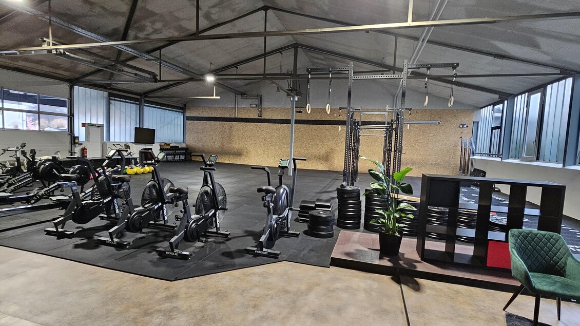 Ein modernes Fitnessstudio mit mehreren Fahrrädern und Gewichten. Der Raum hat große Fenster und eine offene, einladende Atmosphäre. | © Laura Reich