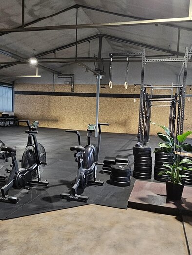 A modern gym with multiple bikes and weights. The room has large windows and an open, inviting atmosphere. | © Laura Reich