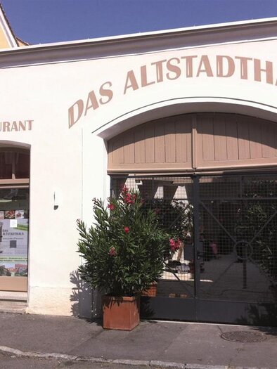 A charming building with the inscription "The Old Town House." Large potted plants stand in front of the entrance. | © Das Altstadthaus