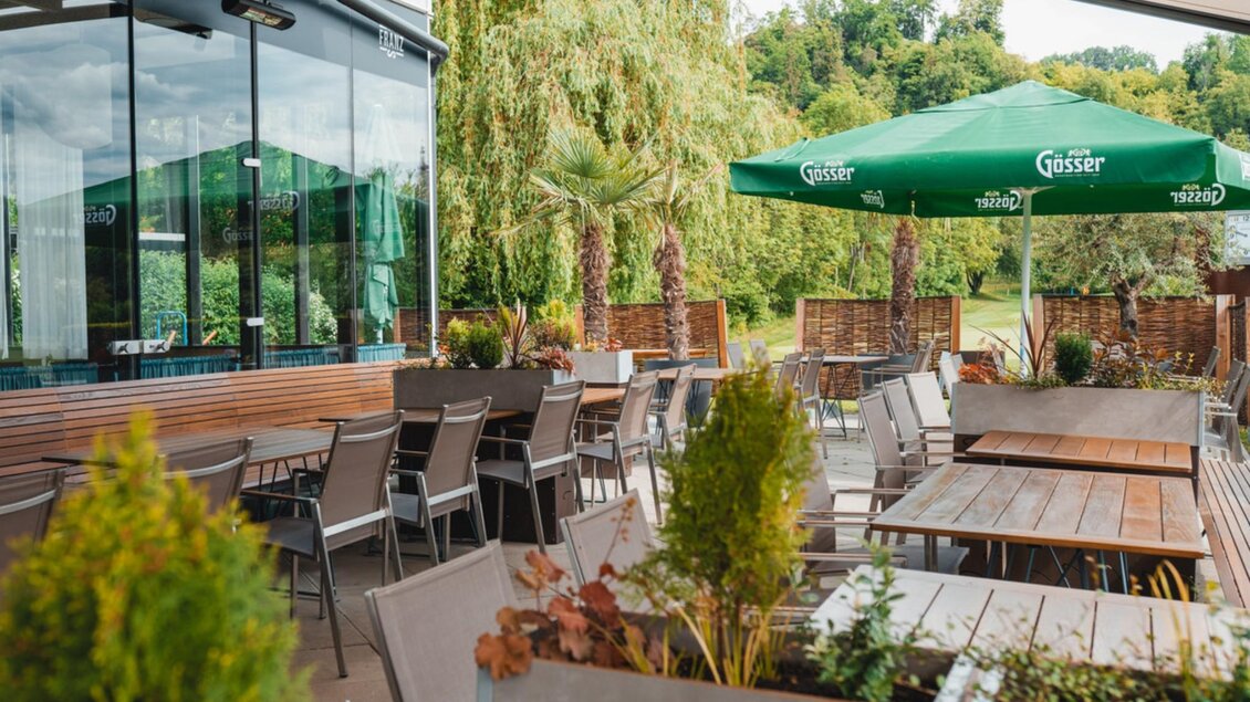 Die Terrasse des „Das Franz“ mit Sitzplätzen und grünen Pflanzen, Blick auf Garten und Bäume. | © Das Franz