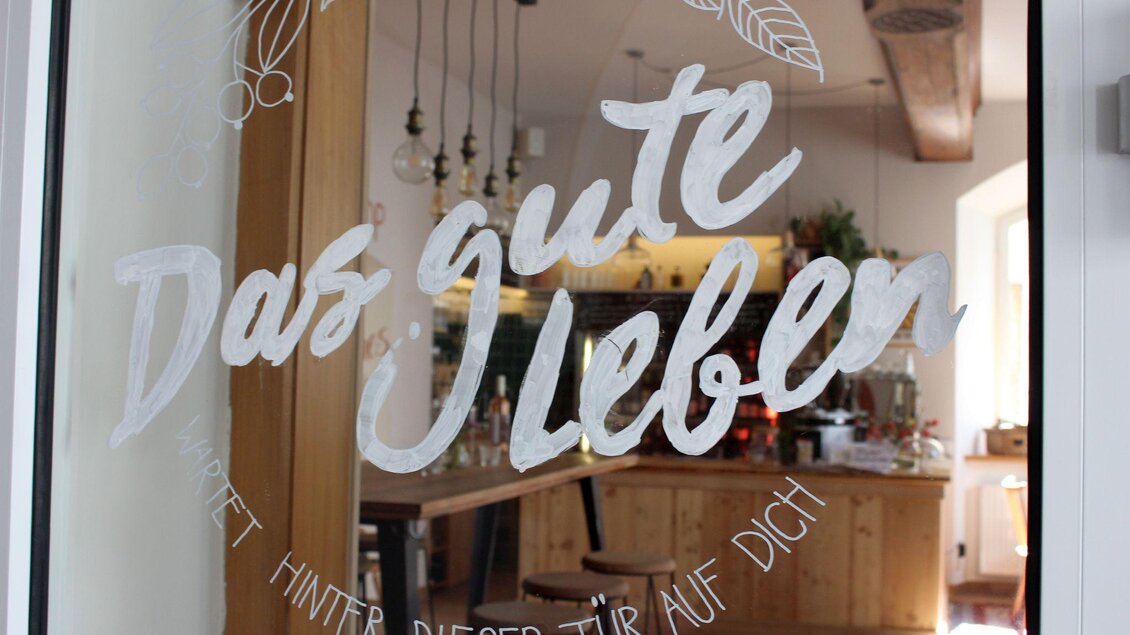 Ein einladendes Café mit großem Holzinterieur. Auf der Fensterscheibe steht der Schriftzug "Das gute Leben". | © TVB Ausseerland - Salzkammergut_Viola Lechner