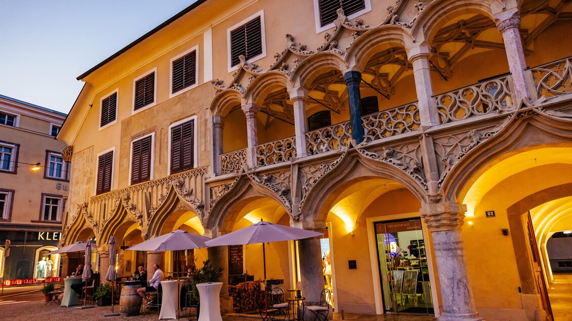Ein historisches Gebäude mit schönen Bögen und kunstvollen Verzierungen. Die Szenerie ist abends beleuchtet und lädt zu einem gemütlichen Aufenthalt ein. | © Wolfgang Spekner