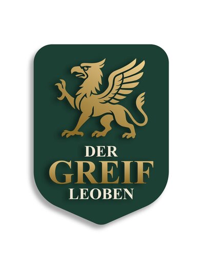 A green building with the inscription "Gasthof Zum Greif". There are flowers at the windows and an entrance with a striped pattern. | © Der Greif