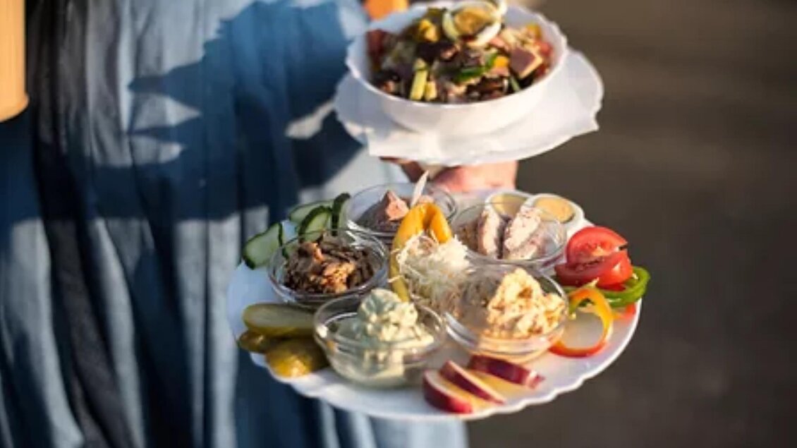 Ein Tablett mit verschiedenen appetitlichen Speisen, darunter Salat und Dips. Das Geschirr ist kreativ angerichtet und zeigt eine bunte Auswahl an frischen Zutaten. | © Fam. Hernach | Der Hermannhof