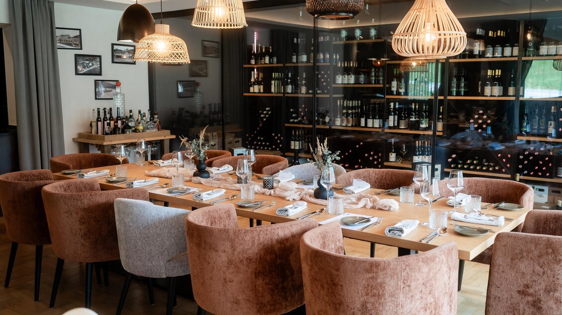 Ein eleganter Essbereich mit gepolsterten Stühlen und einem langen Holztisch. Die Einrichtung ist modern und geschmackvoll, ergänzt durch stilvolle Lampen. | © Der Literwirt