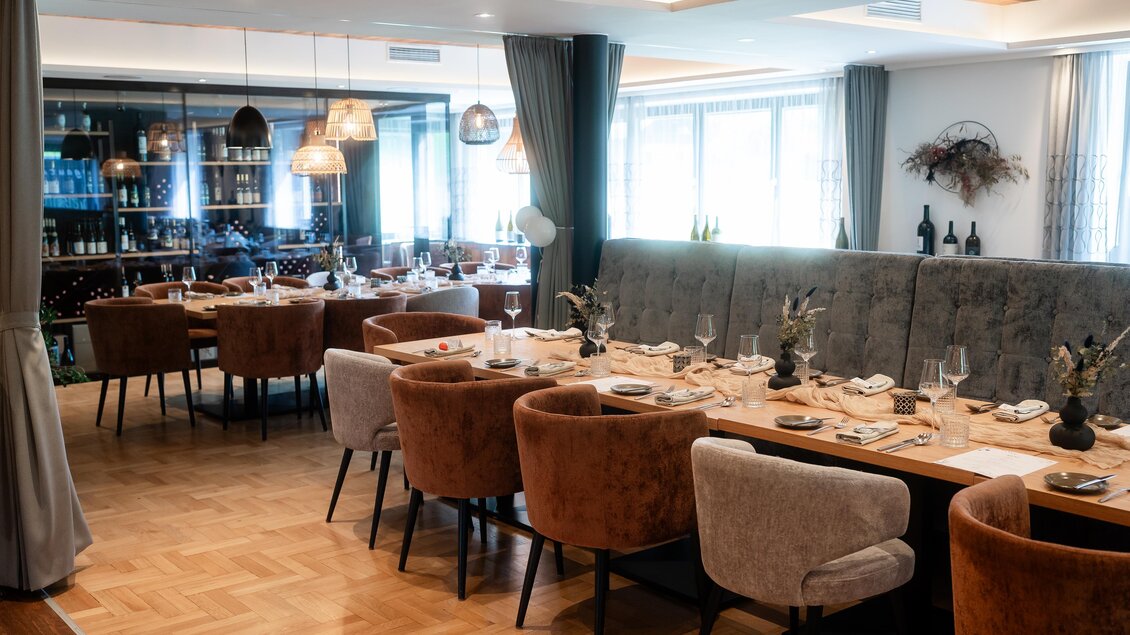 Ein eleganter Restaurantbereich mit modernen Stühlen und gedeckten Tischen. Große Fenster lassen viel Licht herein und schaffen eine einladende Atmosphäre. | © Der Literwirt