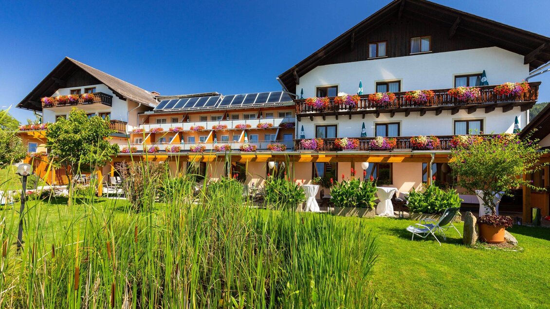 Ein charmantes Hotel mit blühenden Balkonen und einem gepflegten Garten. Die Gebäude sind von einer schönen Landschaft umgeben und bieten eine entspannte Atmosphäre. | © TV Semriach - Harry Schiffer