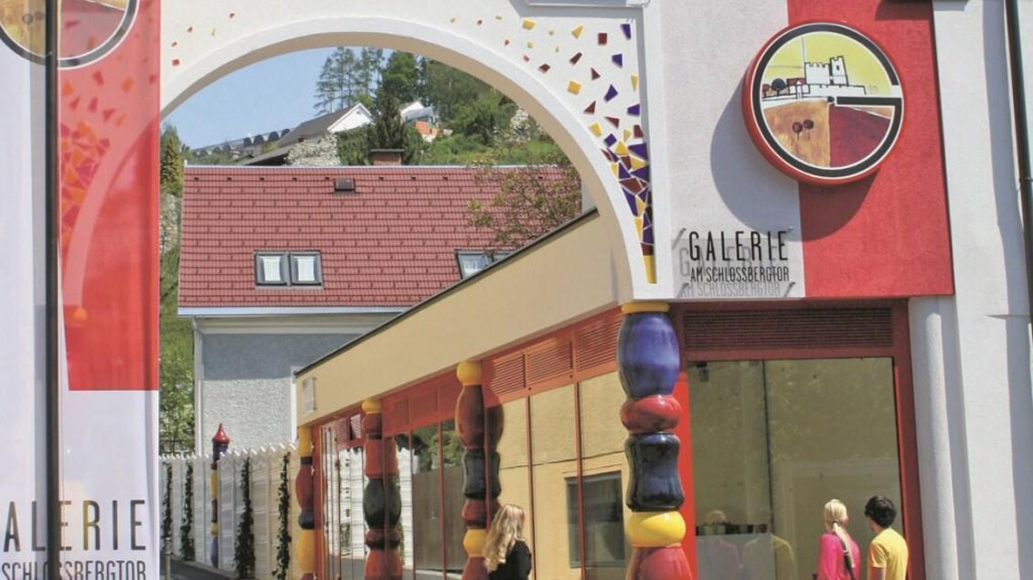 Eine moderne Galerie mit bunten Elementen und einem großen Eingangsbereich. Menschen gehen vorbei und erkunden die Kunst. | © Robert Cescutti