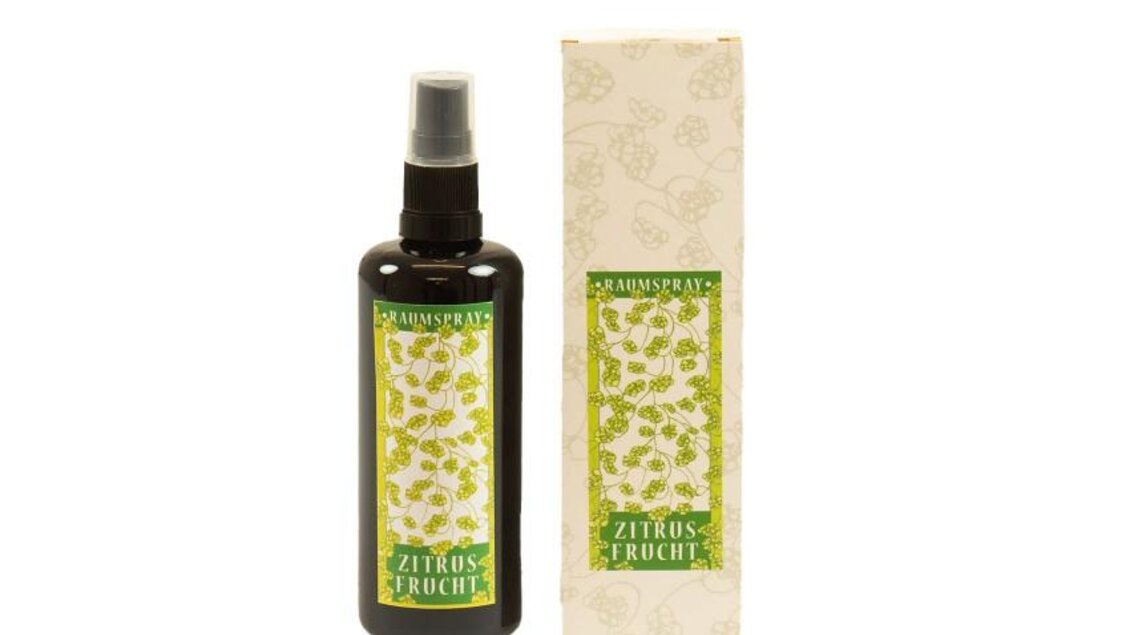 Ein brauner Sprühflasche mit der Beschriftung "Zitrusfrucht" und einem eleganten Verpackungsdesign. Das Produkt scheint ein Raumspray zu sein, das einen frischen Duft verspricht.