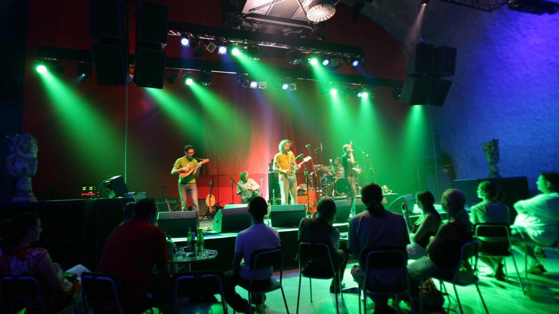 Konzert im Dom im Berg mit grünem Bühnenlicht und Publikum im Gewölbe | © Graz Tourismus - Harry Schiffer