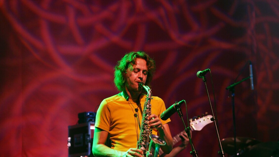 Musiker spielt Saxofon auf Bühne im Dom im Berg mit Lichtprojektionen | © Graz Tourismus - Harry Schiffer